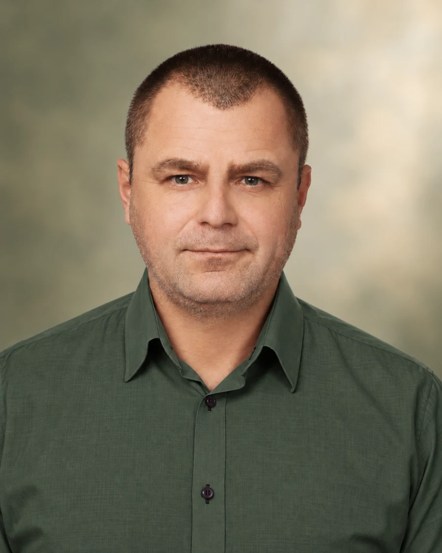 Portret Kacpra Radzkiego w ciemnozielonej koszuli na oliwkowym tle